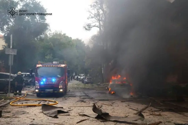 Автор фото, Володимир Зеленський Вулиця після обстрілу, уламки та горить машина. Стоїть машина рятувальників
