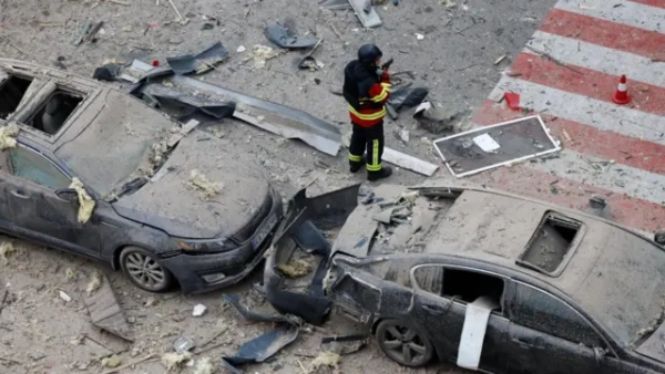 Автор фото, Thomas Peter via Reuters Пошкоджені і вкриті пилом авто, поруч із ними рятувальник