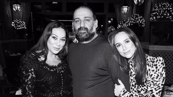 чорно-біле фото бородатого чоловіка з двома жінками, молодша обіймає його за плечі