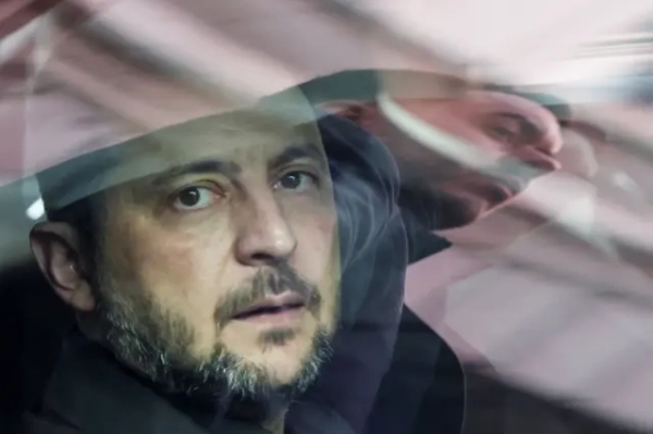 Відображення співробітника служби безпеки з'являється на вікні автомобіля, в якому сидить президент України Володимир Зеленський.