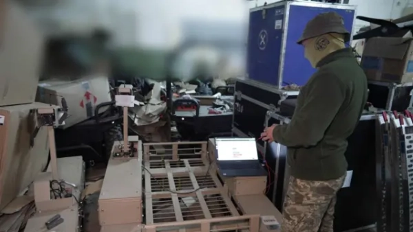 Чоловік у складі налаштовує наземний дрон 