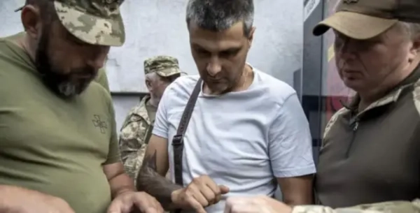 Автор фото, Reuters Працівники ТЦК перевіряють документи в чоловіка на телефоні